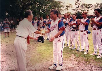 大会3連覇を成し遂げたブルートス田浦賢監督(右)と優賞トロフィーを贈呈する北條猛マニラ日本人会会長