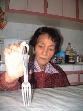 58年前にカンルーバン収容所で支給されたフォークを手にする尾辻ヨシさん