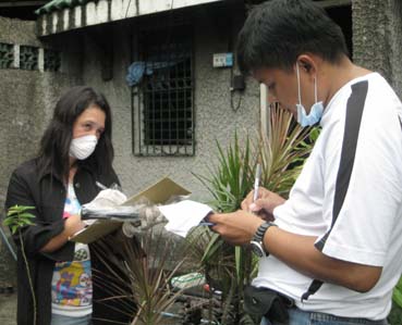 岡さんの遺体が発見された自宅と、その付近を捜査するラスピニャス署員=首都圏ラスピニャス市で30日正午ごろ写す