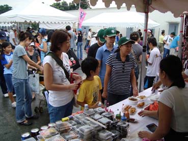 フィエスタの出店で日本食を購入する親子連れ=首都圏タギッグ市のマニラ日本人学校で23日正午ごろ写す