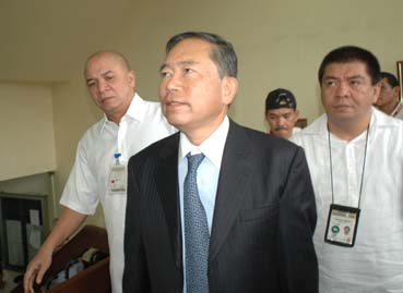 入管職員に連行される小川真澄容疑者=24日午後4時ごろ首都圏マニラ市で写す