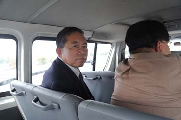マニラ空港到着時に第2ターミナルの方向を見つめる小川真澄容疑者=入国管理局の搬送車両内で10日午後0時半ごろ写す
