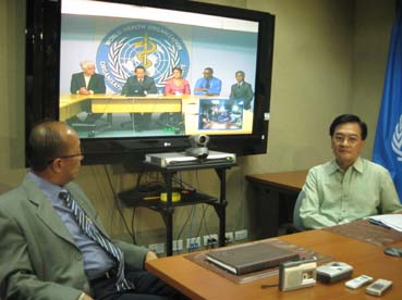 ジュネーブから中継で記者会見するドゥケ厚生長官=WHO西太平洋事務局で21日午後10時半ごろ写す