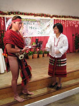 地元版母子手帳の贈呈を受けるイフガオ州のバギラット知事(左)