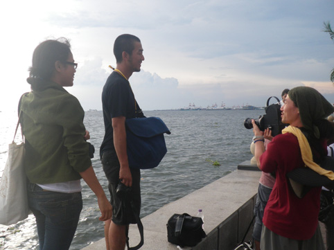 マニラ湾の夕日を待つ学生たち=28日午後、首都圏マニラ市で写す
