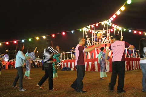 やぐらを囲んで盆踊りを踊る来場者ら=首都圏タギック市のマニラ日本人学校で7日午後7時ごろ写す