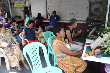 パッションを詠唱する比人女性=20日午後4時ごろ、首都圏マニラ市トンドで写す