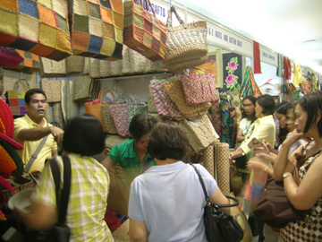 比各地の特産品が展示され、買物客でにぎわう会場=21日午後2時すぎ、首都圏マンダルーヨン市のSMメガモールで写す