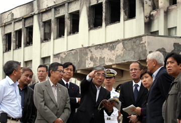 被災した門脇小学校前で石巻市の亀山紘市長から説明を受けるアキノ大統領=大統領府提供
