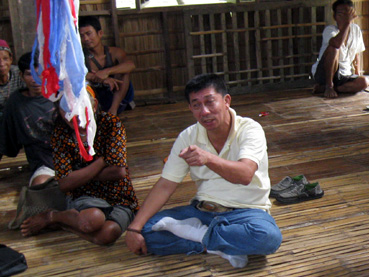 先祖らの遺骨を盗まれたマンギャン民族の被害者らと話すモランテさん=12日、ルソン地方東ミンドロ州マンサライ町パナイタヤンで写す