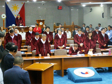 開廷直後、法服姿で祈りをささげる陪審員の上院議員ら=16日午後2時すぎ、首都圏パサイ市の上院本会議場で写す