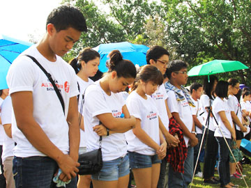 東日本大震災の犠牲者へ黙とうをささげる参加者=11日午前9時ごろ、首都圏ケソン市の比大ディリマン校で写す