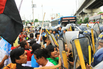警官隊ともみ合うデモ隊=15日午後4時50分ごろ、首都圏ケソン市のエドサ通りで写す