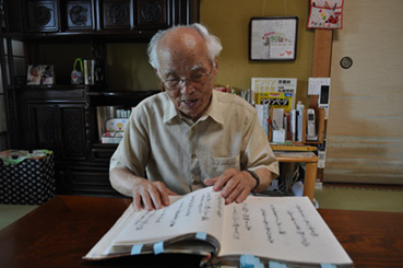 モンテンルパ時代に自ら作った短歌や独房内のデッサンなどをまとめた私家本を自宅で見る宮本さん=京都府与謝野町の宮本さん宅で写す