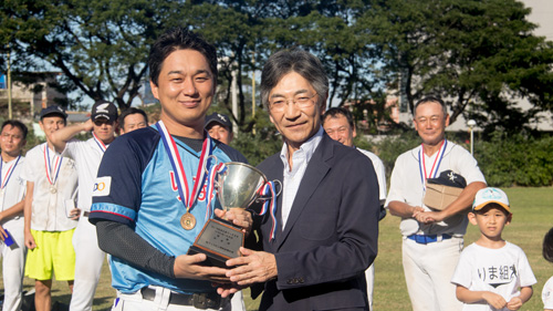 石川和秀駐比日本大使(右)から優勝杯を受け取るりま組の小倉監督=20日午後3時、首都圏タギッグ市のマニラ日本人学校グラウンドでモンティ・シ撮影
