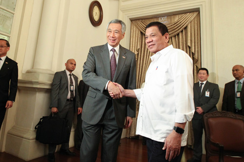 シンガポールのリーシェンロン首相と握手するドゥテルテ大統領=大統領府提供