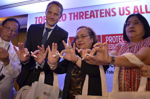 禁煙を訴えたばこを折るウビアル厚生長官ら=30日首都圏マニラ市イントラムロスで伊藤明日香撮影