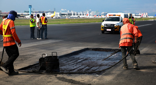 滑走路にあいた穴を埋める緊急修復作業が行われた=30日午後3時45分ごろ、マニラ空港で撮影