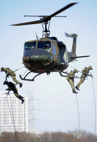 無償供与される多用途ヘリコプターUH?1Hを使用して降下訓練を行う陸上自衛隊=2012年1月、千葉県習志野市で撮影(AFP=時事)