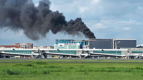 ホテル建設現場での火災で上がる黒煙=マニラ空港公団提供