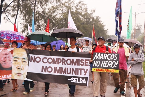抗議の声を上げながら英雄墓地に向かって行進する人権団体関係者ら=首都圏タギッグ市で遠藤美波撮影