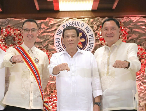 大麻使用発言をした直後、「ドゥテルテポーズ」でカエタノ前外務長官(左)らと写真撮影を行う大統領(中央)=大統領府提供