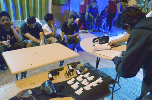 逮捕された容疑者らと押収された覚せい剤、銃器など=13日午前1時半ごろ、首都圏マカティ市で伊藤明日香撮影