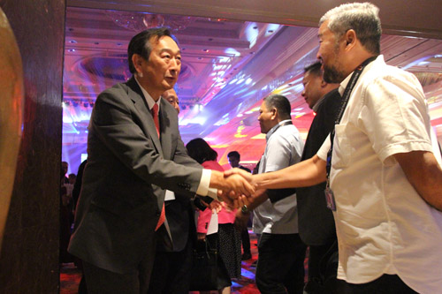 来場者と笑顔で握手を交わす三菱自動車フィリピンの押切武津洋社長(左)=8日午後6時半ごろ、首都圏マカティ市で森永亨撮影