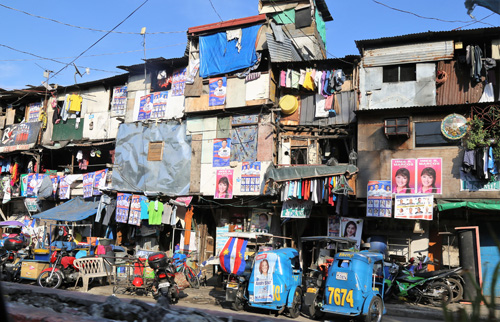 住宅密集地のそこかしこに貼られた選挙ポスター=4日、首都圏マニラ市のサンタアナ地区で石山永一郎撮影