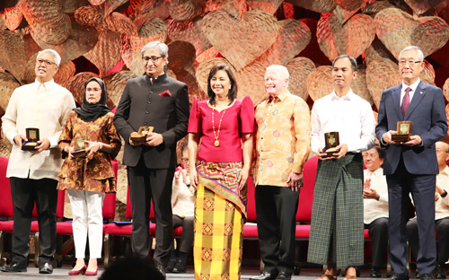 中央はロブレド副大統領、その右にマグサイサイ財団のホセ・クイシア理事長、左から受賞者のライアン・カヤブヤブ氏、アンカナ・ニーラパイチット氏、クマル・ラビッシュ氏、コ・スエ・ウィン氏、キム・ジョンキ氏=9日午後6時過ぎ、首都圏マニラ市マラテの比文化センターで岡田薫撮影