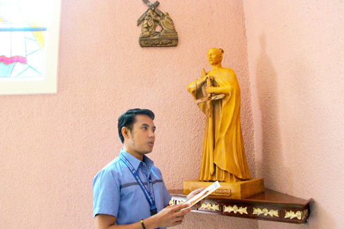 マニラ市立大聖堂内に設置された高山右近像と聖堂管理者のチャールズケイセル・マドリガルさん=7月、國眼綾乃撮影