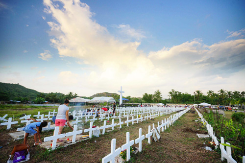 台風ヨランダで亡なった犠牲者の墓地に慰霊に訪れた住民=8日、レイテ州タクロバン市(AFP=時事)