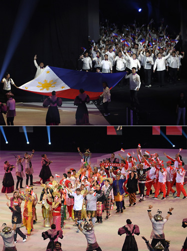 (上)30日に首都圏北方ブラカン州のフィリピンアリーナでの東南アジア競技大会開会式で国旗を手に入場する比選手団(EPA=時事)。(下)30日、首都圏北方ブラカン州のフィリピンアリーナでの東南アジア競技大会の開会式(AFP=時事)