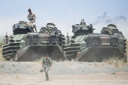 第35回比米年次合同軍事演習「バリカタン」に参加した両軍の兵士と米軍の水陸両用装甲車。米軍は強襲揚陸艦「ワスプ」を小型空母に見立て、最新鋭ステルス戦闘機F35B10機、垂直離着陸型MV22オスプレイ4機を搭載、南シナ海上空などで訓練を展開したと報じられた=2019年4月11日、ルソン中部サンバレス州サンアントニオ町(EPA=時事)
