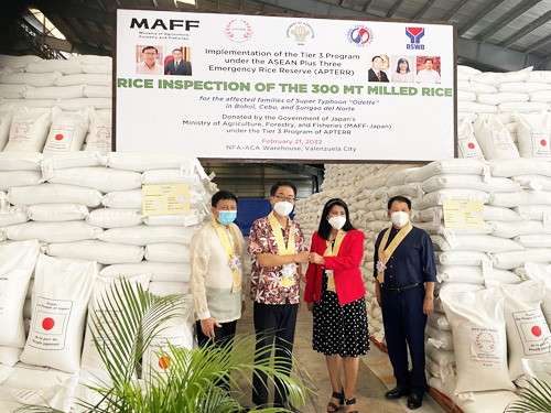 日本の供与米と越川和彦大使(左から2人目)、ジュディー・ディンサルNFA長官(同3人目)ら=21日、大使館公式フェイスブックより