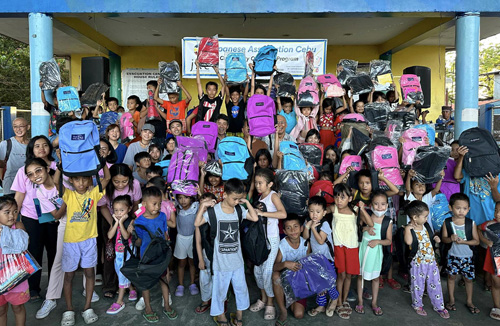 昨年末の大規模火災で被災した子どもたちへのセブ日本人会による学用品などの支援活動の様子=6日、セブ州ラプラプ市プソクのサンタマリア地区で(内山順子さん提供)