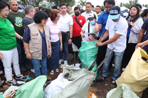 パサイ市のマニラ湾沿いで清掃活動を視察するロイザガ氏ら=環境天然資源省提供写真