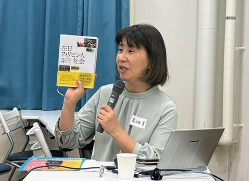 自著を手に講演する静岡県立大の高畑教授=高畑教授提供写真