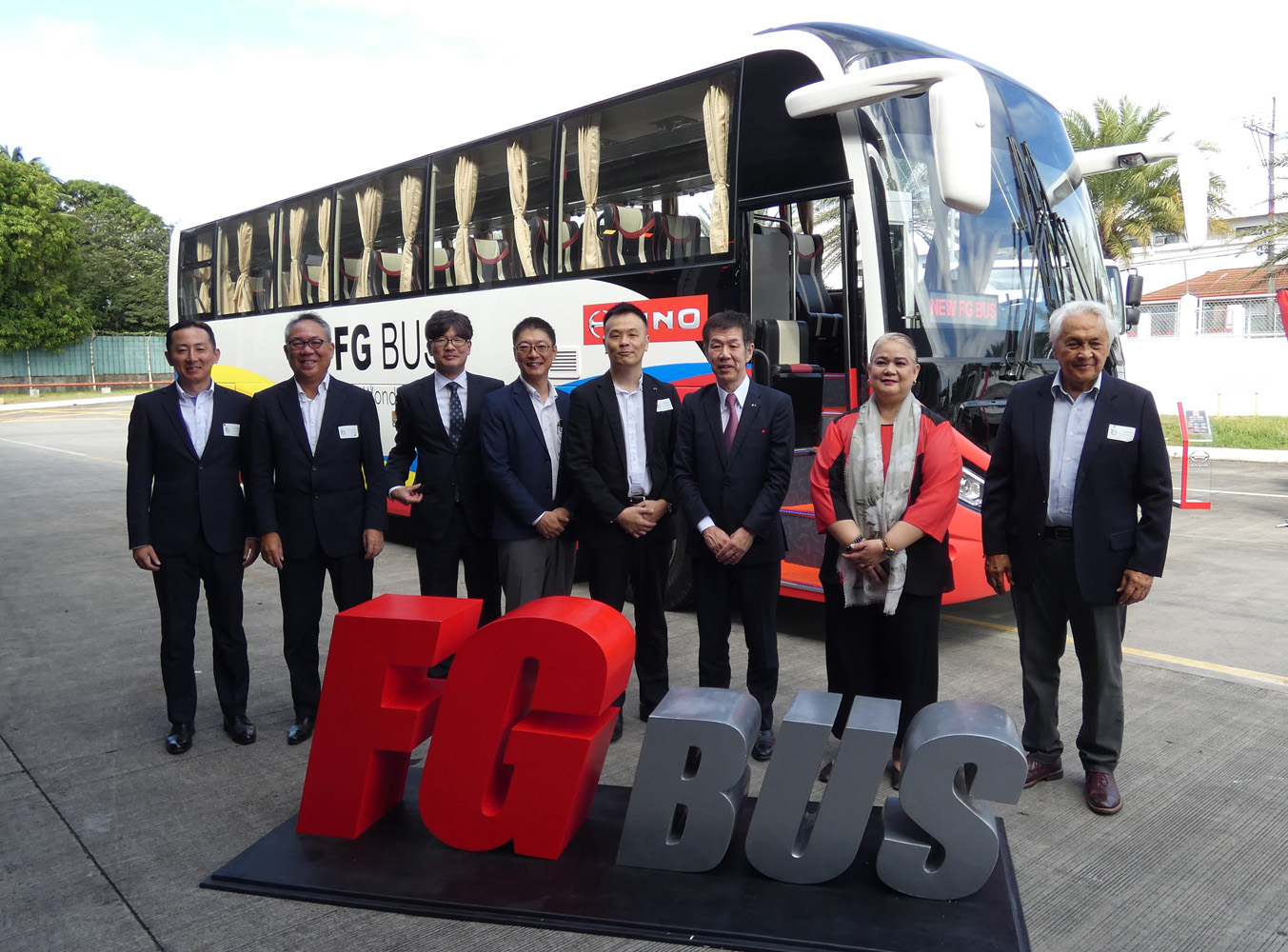 新商品「FG Bus」の前に並ぶ小木曽聡日野自動車株式会社取締役社長(右から3人目)、貿易産業省産業開発サービス局のマリア・ディチョーサ局長(右から2人目)、ビセンテ・ミルズHMP会長(右から1人目)ら主賓と同社幹部=2025年1月21日にラグナ州カランバ市の同本社で萩原裕之撮影