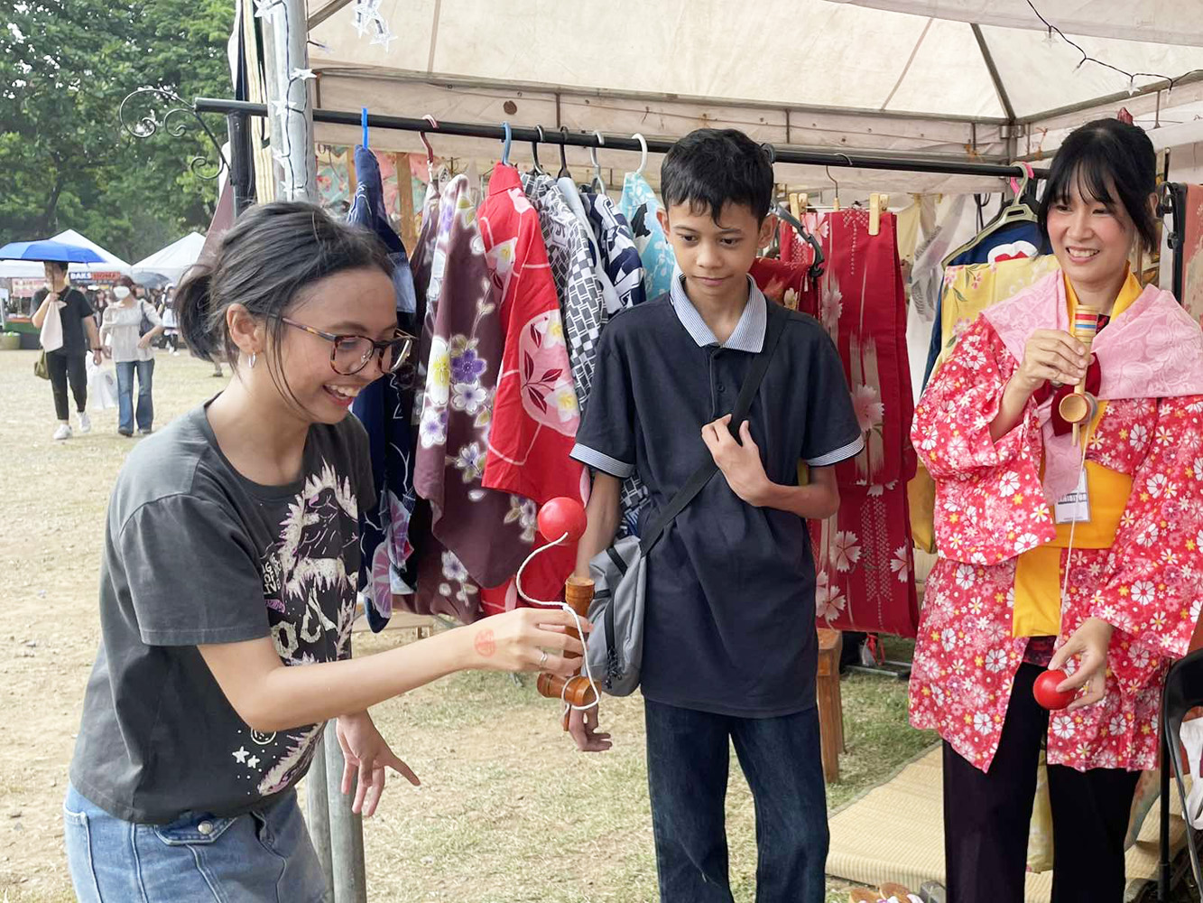 けん玉を楽しむ高校生の来場者=5月11日、マニラ市キリノ・グランドスタンドで宇井日菜撮影